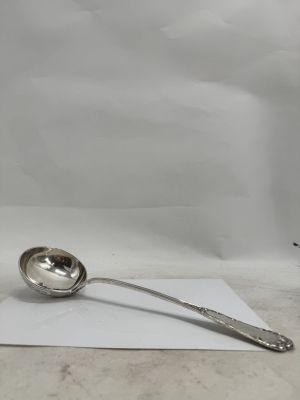 a silver spoon sitting on top of a piece of paper next to a cup