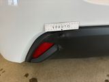 the rear end of a white car with a sticker on it ' s bumper