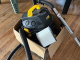 un aspirateur posé dans un carton par terre
