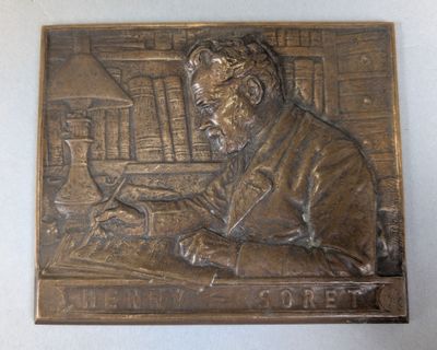 a bronze plaque of a man sitting at a desk
