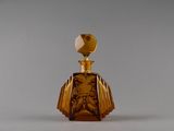 une petite bouteille en verre ornée d'un motif doré