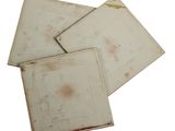 three pieces of old white paper with rust on them on a white surface