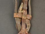 an old knife with a leather sheath hanging from it ' s side