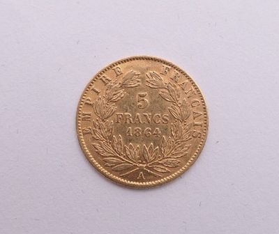 gros plan d'une pièce d'or sur une surface blanche