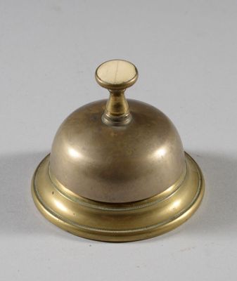 une cloche posée sur une table, sur une surface blanche