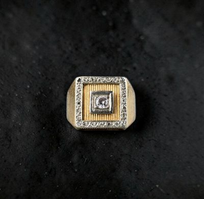 a close up of a gold and diamond ring on a black surface