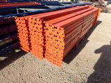 many piles of orange steel bars stacked on top of each other
