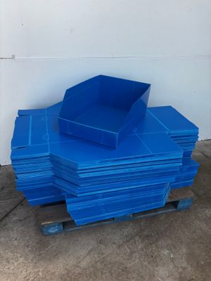 a pile of blue plastic bins sitting on top of a pallet