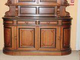 a wooden china cabinet with a mirror on top of it