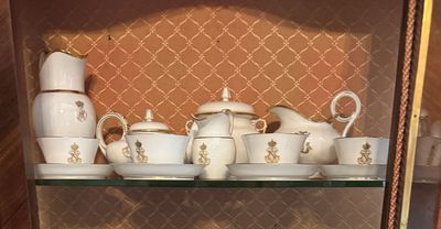 une vitrine remplie de vaisselle blanche et dorée