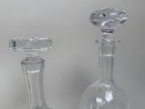 two glass bottles with a diamond shaped stopper on them