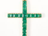 un gros plan d'un pendentif en forme de croix verte sur fond blanc