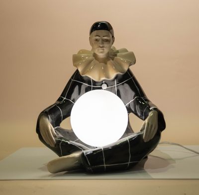 a figurine of a woman sitting in a lotus pose with a glowing ball in her hands