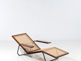the lounge chair is made of rattan and has a wooden frame