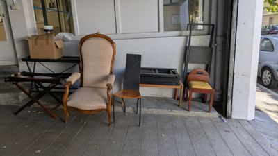 deux chaises et une table sous le porche d'un immeuble