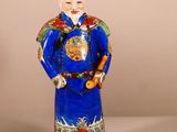 une image représentant une figurine d'un homme vêtu d'un costume bleu et d'un chapeau