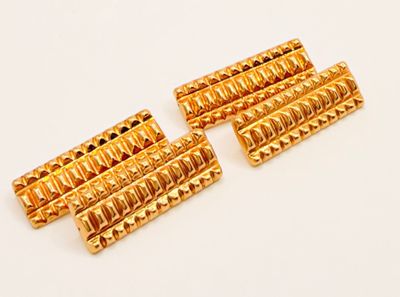 a set of four gold plated metal rollers on a white surface