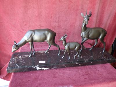 statue représentant trois cerfs et un faon, posée sur un socle en marbre