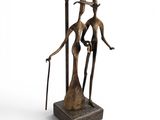 une statue en bronze représentant un homme et une femme tenant des bougies