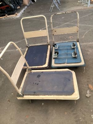 two chairs that have wheels on them in a parking lot
