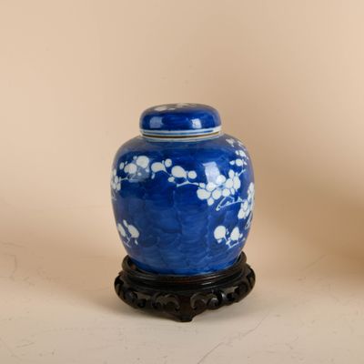 a blue vase with white flowers on it on a stand