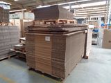 a large stack of boxes in a warehouse with pallets of wood