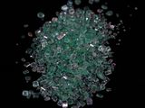 a pile of green crushed glass on a black surface
