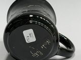 a black coffee cup with writing on it sitting on a table