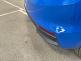a close up of a blue car parked in a parking lot