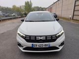 the front view of a white car parked in a parking lot