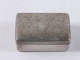 une vieille boîte en argent posée sur une surface blanche