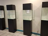 three glass display cases in the corner of a room