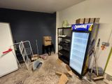 a refrigerator in the middle of a room that is being remodeled
