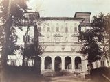 une vieille photo d'un grand bâtiment avec une horloge sur la façade