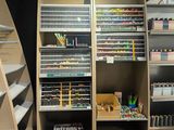 a lot of pens and pencils on the shelves in the store