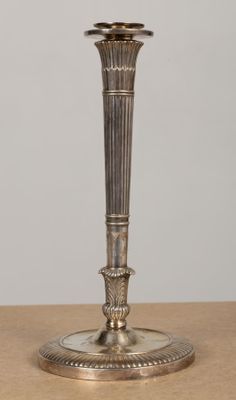 a silver candle holder sitting on a wooden table