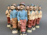 many figurines of men standing next to a ball