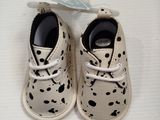 a pair of baby shoes with spots on them