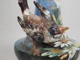 a blue vase with a bird on it and a bee on it