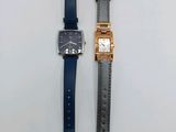 les deux montres sont posées l'une à côté de l'autre sur une surface blanche