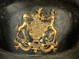 a black and gold hat with a coat of arms on it