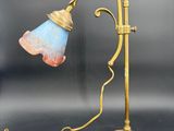 une lampe de table en laiton ancien avec un abat-jour bleu sur fond noir