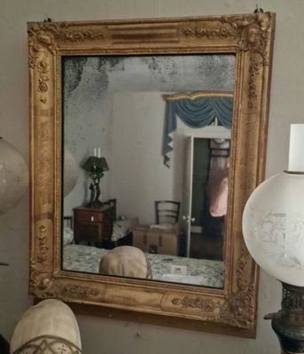 un miroir accroché au mur au-dessus d'une lampe