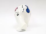 a white owl figurine with blue eyes on it ' s head