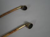 pair of antique brass pipe handles with wooden handles on a white surface