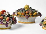 trois figurines en céramique représentant des fruits et des légumes dans un panier