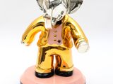 statue of an elephant with a gold crown on a pink base