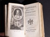 someone is holding an open book with a picture of a man in a crown