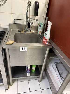 a stainless steel sink in the corner of a kitchen