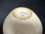 a white vase that has a blue and white design on it